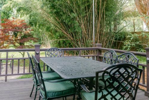 a green table and chairs on a wooden deck at Stylish Private Home 1 mile from Downtown Franklin in Franklin