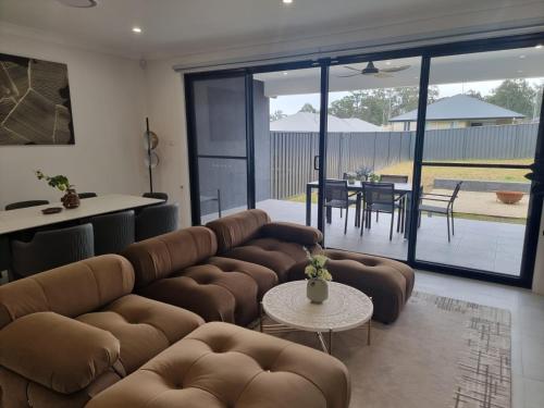 a living room with a couch and a table at Serenity Valley Haven Ellalong in Ellalong
