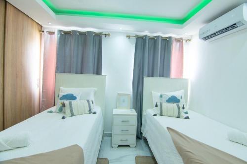 a bedroom with two beds and a green ceiling at Hogar sweet home in Punta Cana