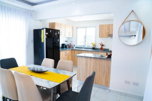 a kitchen with a table and chairs and a black refrigerator at Hogar sweet home in Punta Cana