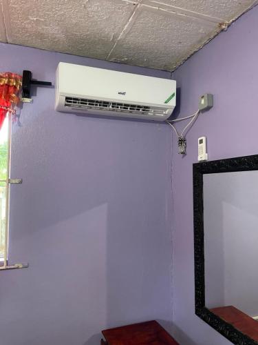 a air conditioner on a wall next to a mirror at Livi's Hide-Away! in Spanish Town