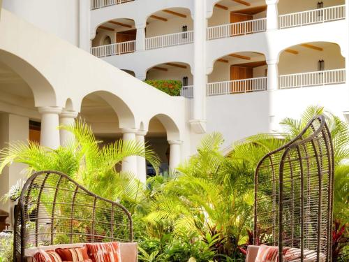 a hotel with two chairs in front of a building at Fairmont Kea Lani, Maui in Wailea