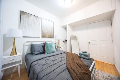 a white bedroom with a bed with blue pillows at Modern Apartment By Central Park - 3 BR in New York