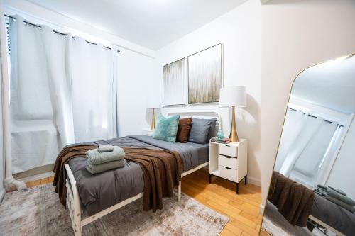 a small bedroom with a bed and a mirror at Modern Apartment By Central Park - 3 BR in New York