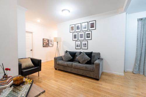 a living room with a couch and a chair at Modern Apartment By Central Park - 3 BR in New York