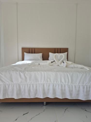 a white bed with two white towels on it at บีริช รีสอร์ท ขอนแก่น in Khon Kaen