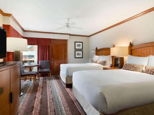 a hotel room with two beds and a television at Fairmont Jasper Park Lodge in Jasper