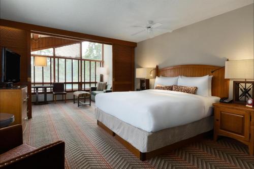 a bedroom with a large white bed and a living room at Fairmont Jasper Park Lodge in Jasper