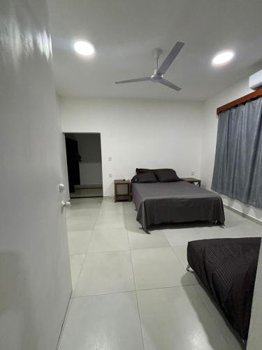 a bedroom with a bed and a ceiling fan at AlcBalam Room in Bacalar
