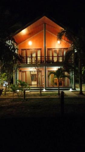 a large building with a balcony in front of it at night at Pearl Cave Cabanas & Resturant in Tangalle
