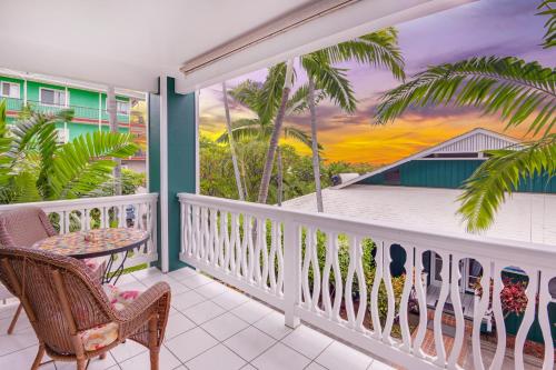 a balcony with a table and chairs and palm trees at Big Island Retreat - No Resort Fees in Kailua-Kona