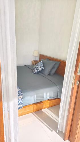 a bed in a small room with a window at Ondokhouse Taro in Gianyar