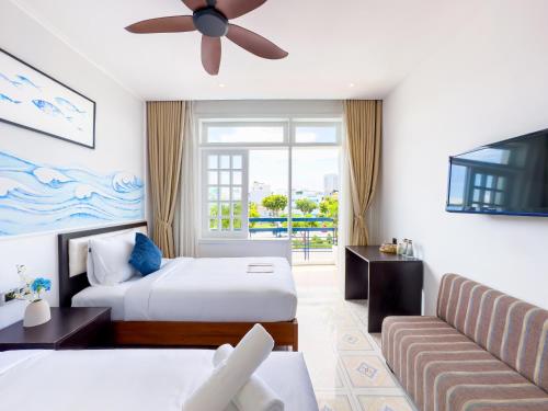 a hotel room with a bed and a couch at Sujet Beach Hotel and Apartment Danang by Haviland in Da Nang