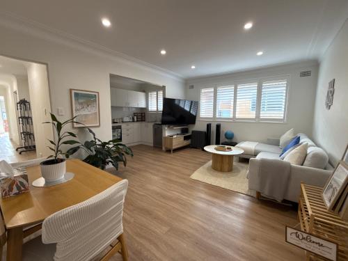 a living room with a couch and a table at Coogee Sunrise shared Apt with Parking, Balcony & Work Desk in Sydney