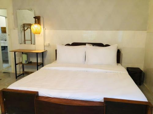 a bed with white sheets and pillows in a room at Home Can Tho in Can Tho