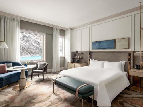 a bedroom with a large bed and a living room at Fairmont Château Lake Louise in Lake Louise