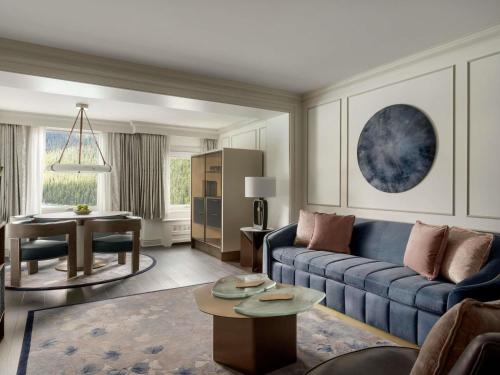 a living room with a blue couch and a table at Fairmont Château Lake Louise in Lake Louise