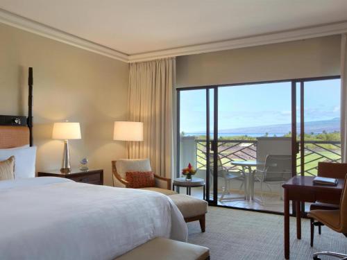 a hotel room with a bed and a balcony at Fairmont Orchid in Waikoloa