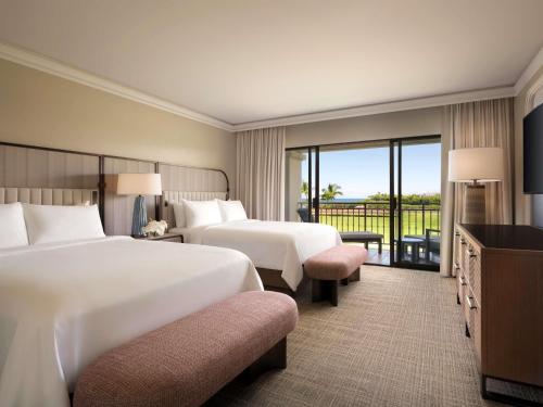 a hotel room with two beds and a balcony at Fairmont Orchid in Waikoloa