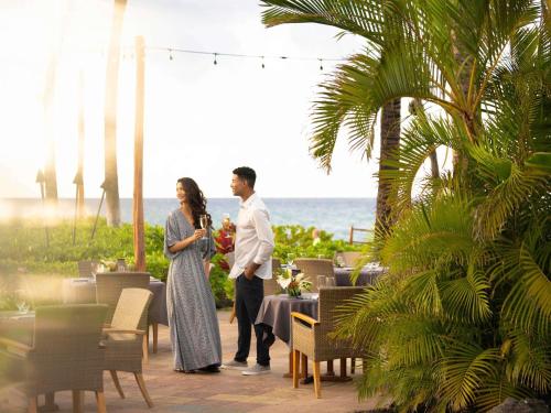 a man and a woman standing in front of a table at Fairmont Orchid in Waikoloa