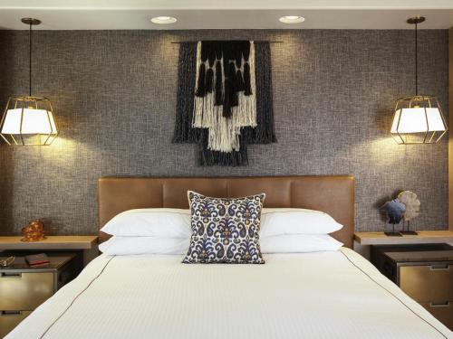 a bedroom with a large white bed with two lamps at Fairmont Scottsdale Princess in Scottsdale