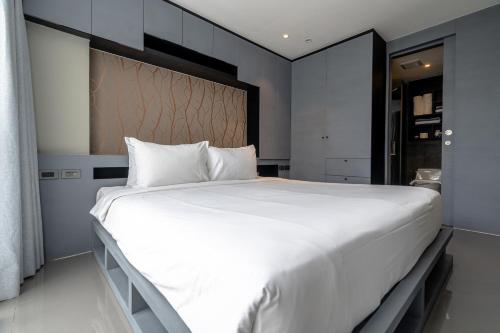 a bedroom with a large bed with white sheets at Suite Celeste 1BR Sunset RooftopCitygate Kamala in Kamala Beach