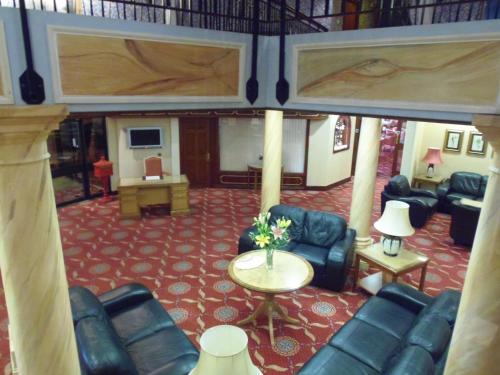 a living room with couches and a table with flowers at Lakeside International Hotel in Camberley
