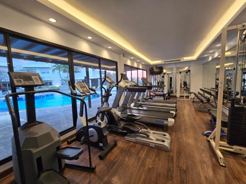 a gym with a bunch of treadmills and ellipticals at Sima Thani Hotel in Nakhon Ratchasima