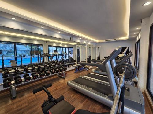 a gym with several treadmills and exercise machines at Sima Thani Hotel in Nakhon Ratchasima