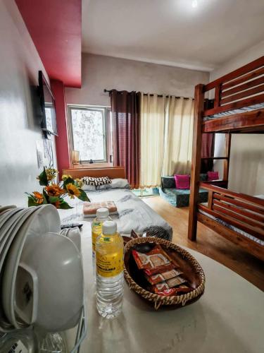 a bedroom with two bunk beds and a table with drinks at Condotel in Baguio City in Baguio