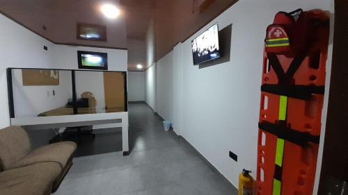 a living room with a couch and a tv on a wall at HOSTAL RANCHO JOTA Murillo Tolima in Murillo