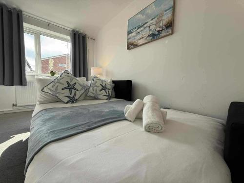 a bedroom with a bed with a towel on it at Monmouth House Aylesbury Premier Quality Accommodation For Larger Families Contractors And Professionals Sleeps Up to 6 Guests in Buckinghamshire