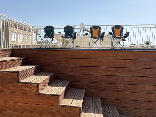 a group of chairs sitting on top of a building at תכלת במושבה in Migdal