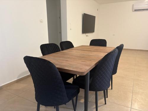 a conference room with a wooden table and chairs at תכלת במושבה in Migdal