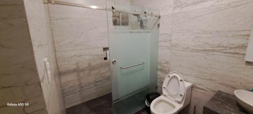 a bathroom with a toilet and a glass shower stall at Alojamiento independiente, ideal para tu tramita de visa in Nuevo Laredo