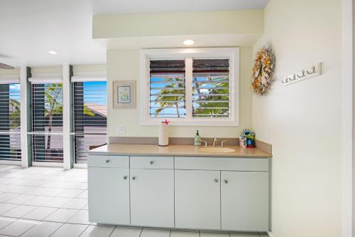 a white kitchen with a sink and a window at Big Island Retreat - No Resort Fees in Kailua-Kona