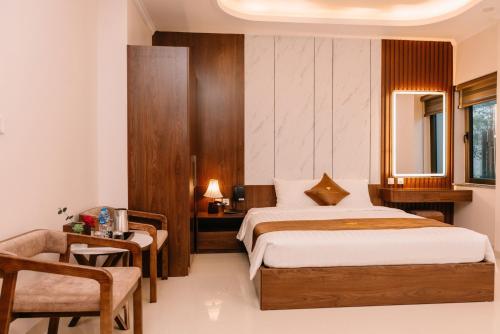 a bedroom with a bed and a desk and a chair at Diamond Hotel in Hai Phong