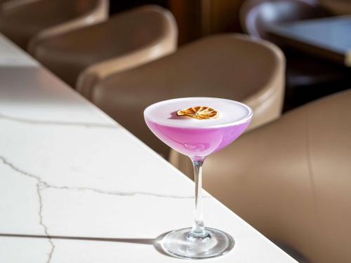 a martini glass with a purple drink on a counter at Fairmont Pittsburgh in Pittsburgh