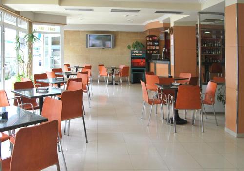 une salle à manger avec des tables et des chaises dans un restaurant dans l'établissement Hotel Plaza, à Portonovo