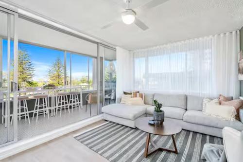 una sala de estar con un sofá y una mesa en Beachfront Bliss 2BR Broadbeach, en Gold Coast