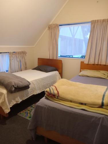 a bedroom with two beds and a window at Budget accommodations city center in Tauranga