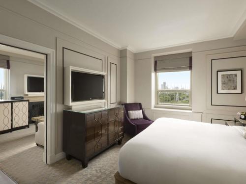 a hotel room with a bed and a television at Fairmont Le Chateau Frontenac in Quebec City
