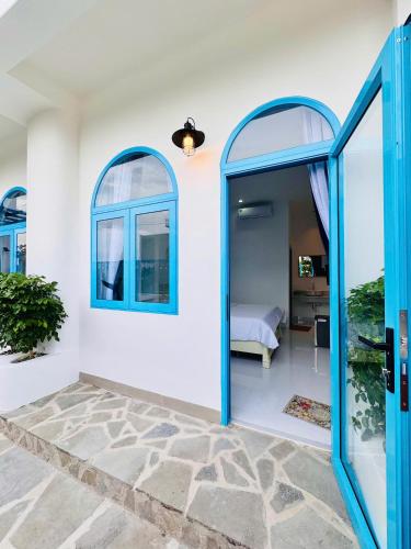 a room with blue windows and a bedroom at Ivory Blue Ninh Chử in Tan An