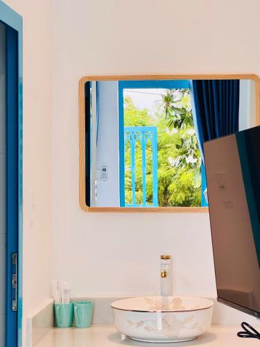 a bathroom with a sink and a mirror at Ivory Blue Ninh Chử in Tan An