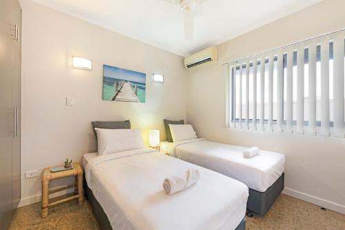 due letti in una piccola stanza con una finestra di Zen City-Venture with Balcony Dining - Cozy - CBD a Darwin