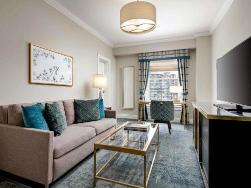 a living room with a couch and a table at Fairmont Empress Hotel in Victoria