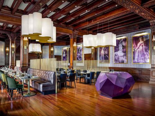 a dining room with tables and chairs and a purple umbrella at Fairmont Empress Hotel in Victoria