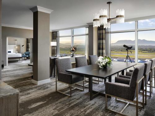 a dining room with a table and chairs and a bedroom at Fairmont Vancouver Airport In-Terminal Hotel in Richmond