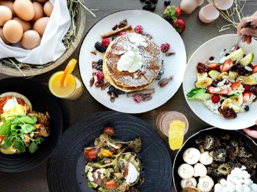 a table topped with plates of breakfast foods and eggs at Fairmont Vancouver Airport In-Terminal Hotel in Richmond