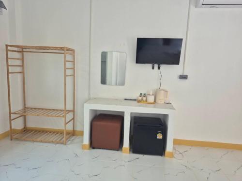 a room with a desk with a tv on a wall at บีริช รีสอร์ท in Ban Pet